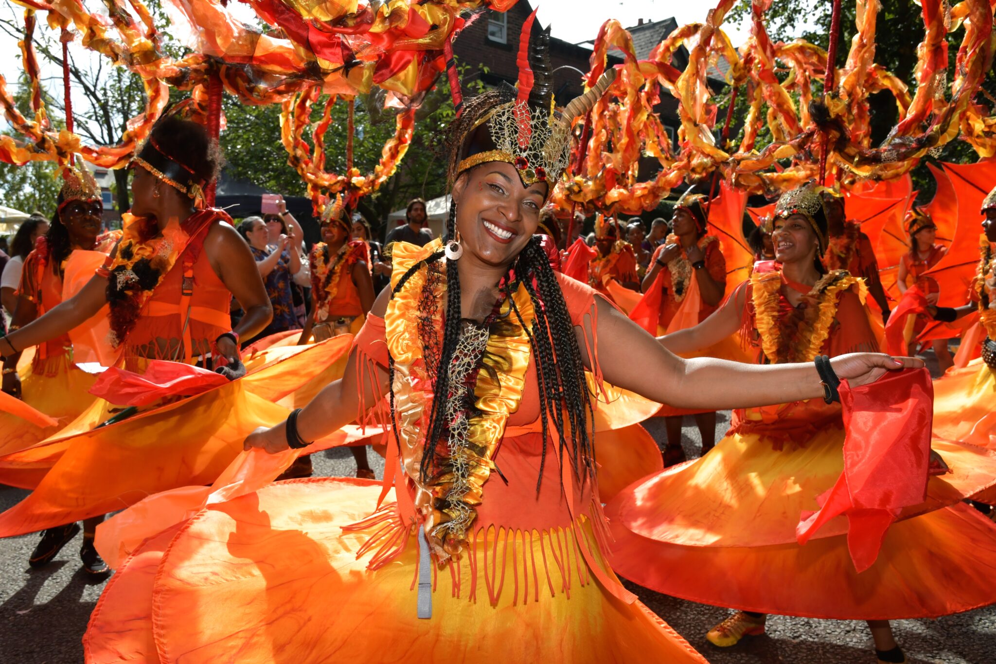 Woman dressed in a bright coloured carnival costume and head piece.